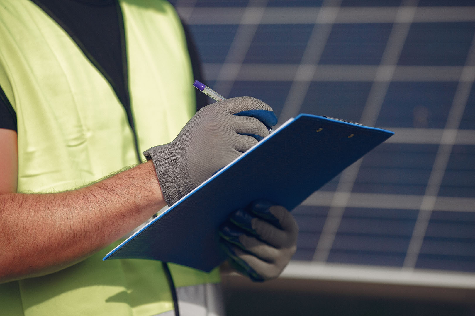 Man in a white helmet near a solar panel